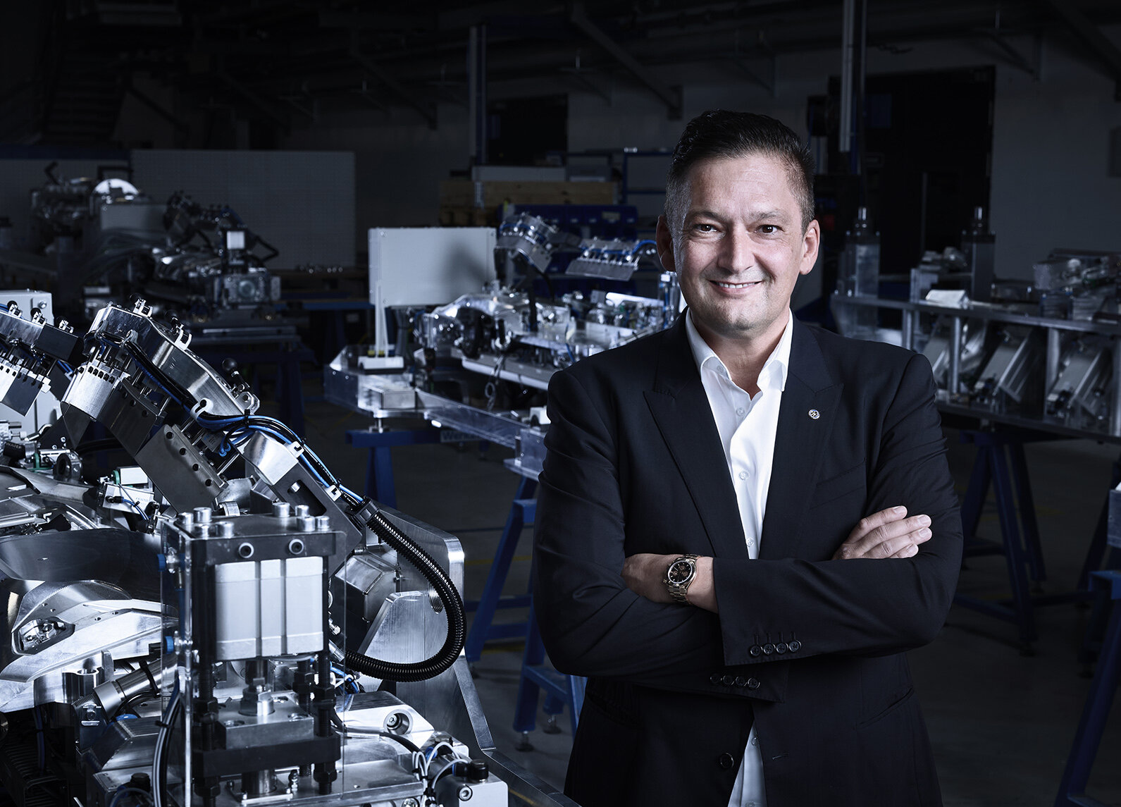 Porträtbild von Hannes Auer in einer Produktionshalle, umgeben von hochentwickelten Maschinen und technischen Anlagen. | © privat