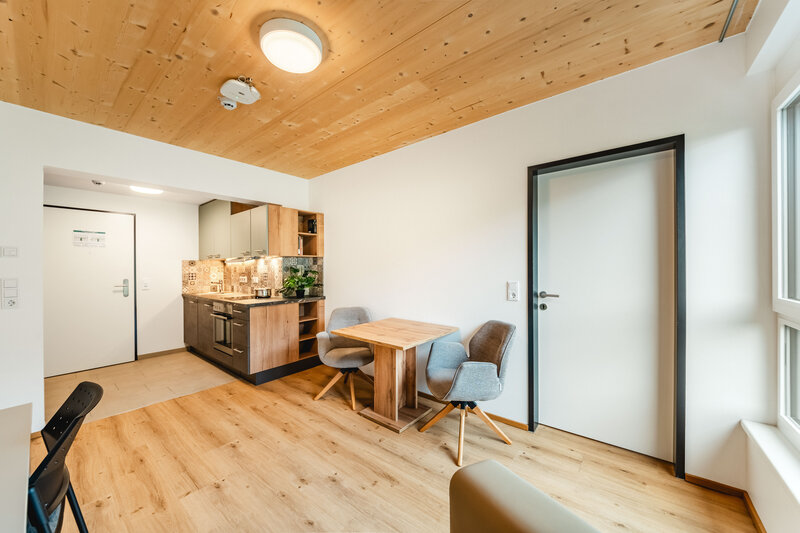 Eine moderne Küche und Essbereich mit Holzböden, Holzdecke und weißen Wänden. | © FH Kufstein Tirol