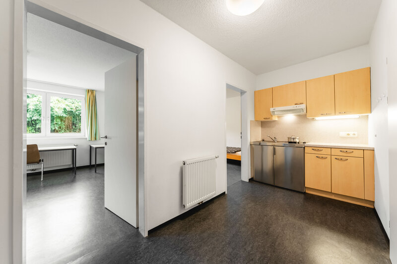 Eine kleine Wohnung mit einer modernen Küche. Im Hintergrund sind zwei Räume sichtbar. | © FH Kufstein Tirol