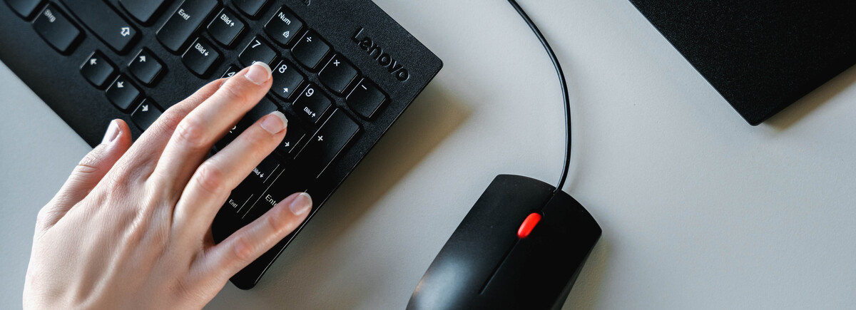 Hand tippt auf eine Computertastatur im Finance Lab der FH Kufstein Tirol.