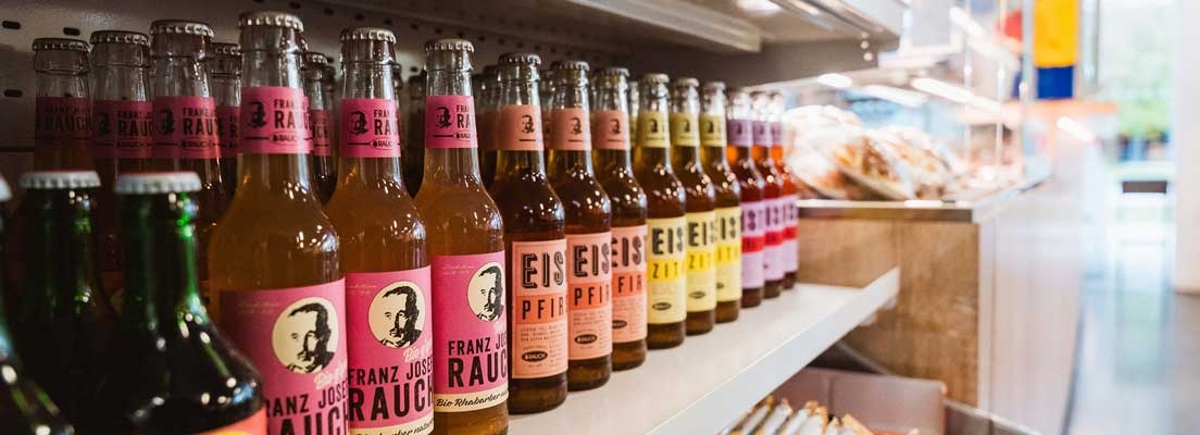 Getränkeregal mit bunten Limonadenflaschen in einem Selbstbedienungsbereich