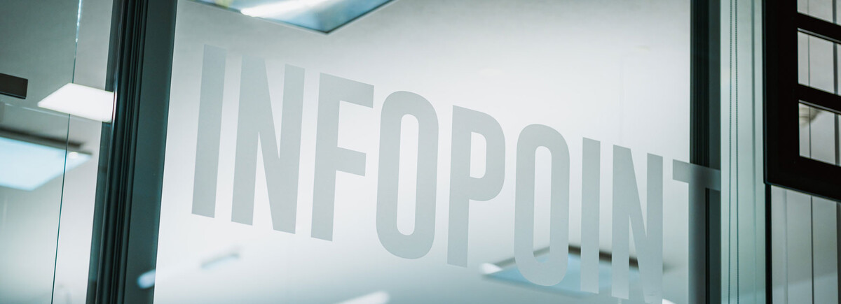 Glasfront mit Infopoint-Schriftzug in einem modernen Gebäude