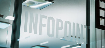 Glasfront mit Infopoint-Schriftzug in einem modernen Gebäude