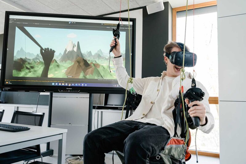Student erlebt virtuelle Paragliding-Simulation mit VR-Brille im Web Lab der FH Kufstein Tirol.