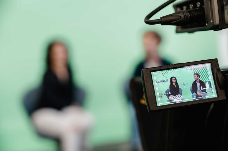 Aufnahme durch Kameradisplay zeigt zwei Studierende bei einem Interview im Media Lab der FH Kufstein Tirol.