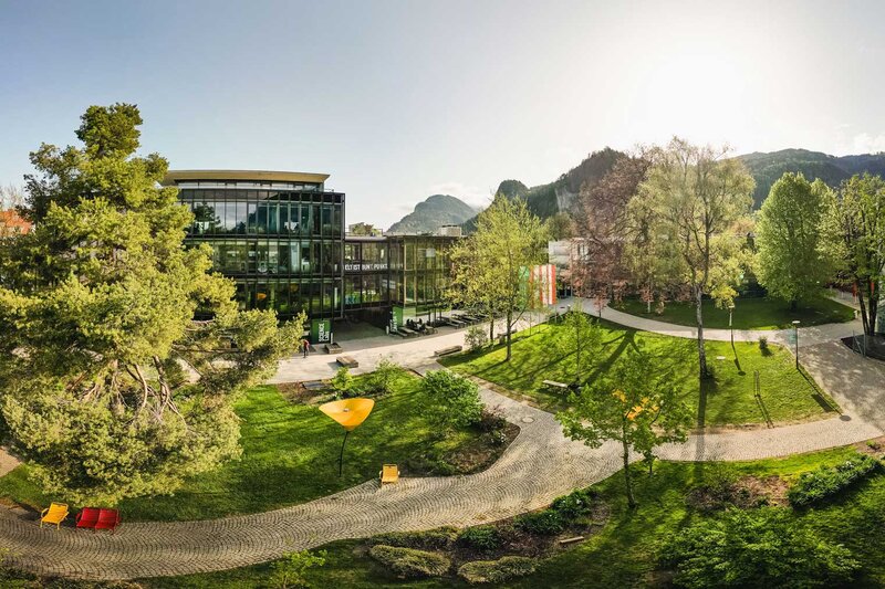 Weitläufiger Campus der FH Kufstein Tirol mit Grünflächen, modernen Gebäuden und Bergpanorama
