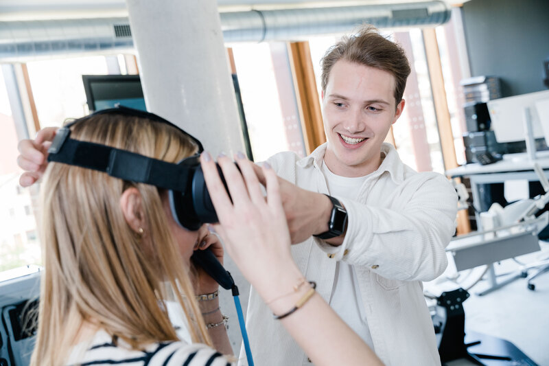 Student hilft Kommilitonin beim Aufsetzen einer Virtual-Reality-Brille im Digital Experience Lab der FH Kufstein Tirol.