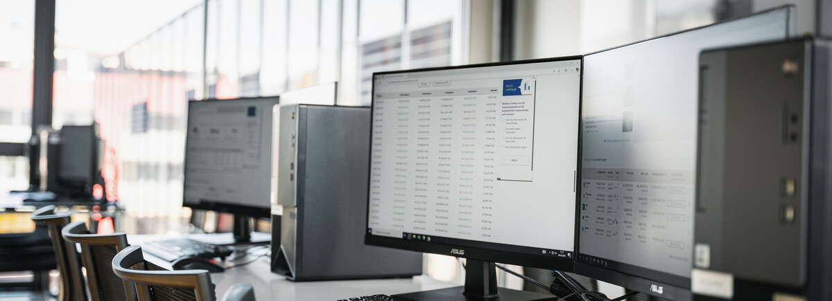 Finance Lab Arbeitsplätze | © FH Kufstein Tirol Ein heller und moderner Computerraum mit mehreren Arbeitsplätzen, ausgestattet mit Monitoren, Tastaturen und PCs, in einer Lernumgebung mit großen Fenstern. | © FH Kufstein Tirol