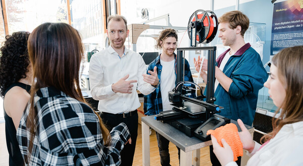 Makers_Lab_3D_Drucker_Vorstellung | © FH Kufstein Tirol Ein Mann stellt anderen Personen im Raum einen 3D Drucker vor, als Teil eines Workshops. | © FH Kufstein Tirol