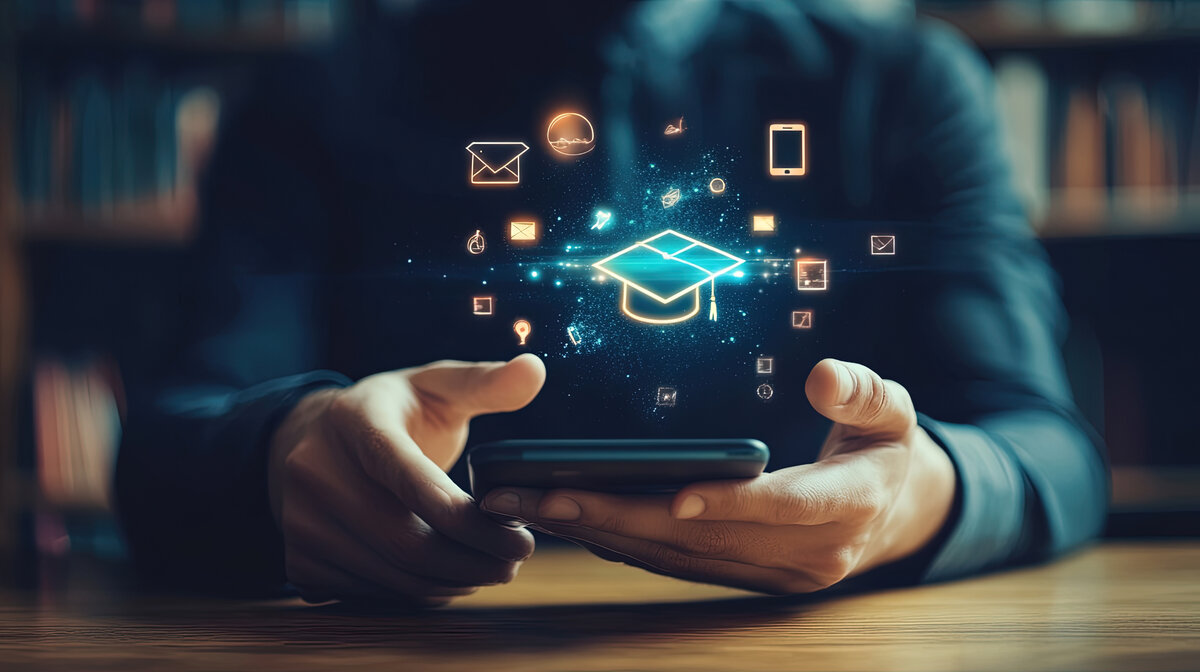 Person hält ein Smartphone, aus dem digitale Symbole und ein leuchtendes Graduationssymbol aufsteigen – Sinnbild für Wissen, Digitalisierung und Künstliche Intelligenz.
