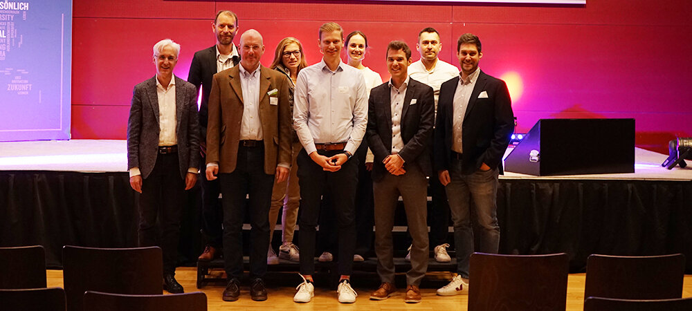 Prof. Dr. Martin Adam, Gastgeber des 23. PQM-Dialogs an der FH Kufstein Tirol, gemeinsam mit den Vortragenden auf der Bühne.