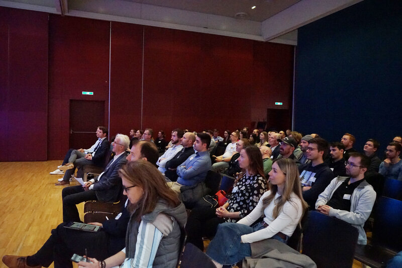 Teilnehmende sitzen im Festsaal der FH Kufstein Tirol und verfolgen aufmerksam einen Vortrag beim 23. PQM-Dialog.