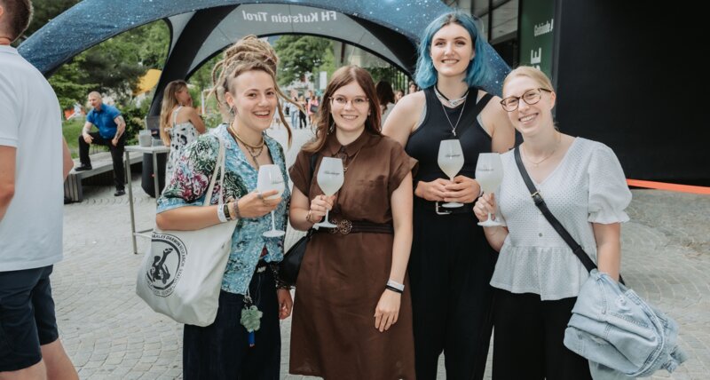 Gäst:innen genießen einen Aperitif im Eingangsbereich der FH Kufstein Tirol. 