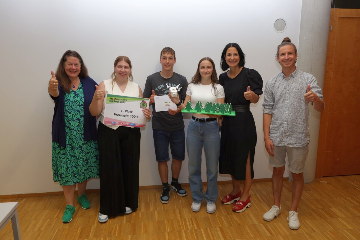Erster Platz bei der Fit4Business School 2025. Das Team Käfer A1 zusammen mit Lehrenden bei Preisverleihung, mittig mit Urkunde und Preisgeld.