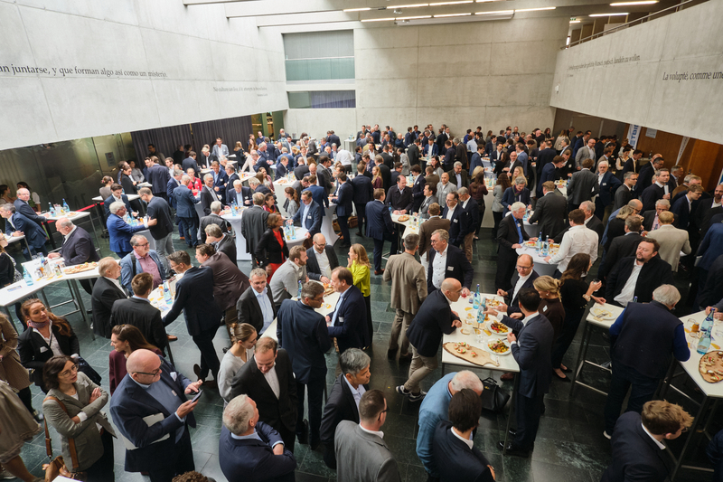 Zahlreiche Konferenzteilnehmer:innen beim 14. Symposium Restrukturierung an Stehtischen in der Aula der FH Kufstein Tirol genießen das Mittagsbüffet-