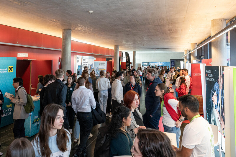Überblick über Foyer des Festsaals der Kufsteiner Hochschule mit zahlreichen Besucher:innen und Messeständen bei der Meet & Match 2026.