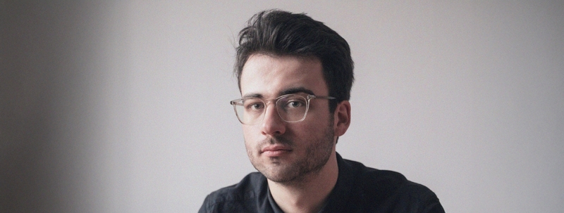 Gregor Schmalzried im Portrait vor einer weißen Wand.