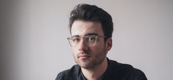 Gregor Schmalzried im Portrait vor einer weißen Wand.