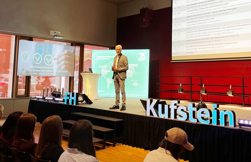 Professor Martin Adam begrüßt die Gäste des 24. PQM-Dialogs 2026 an der FH Kufstein Tirol auf der Bühne im Festsaal.