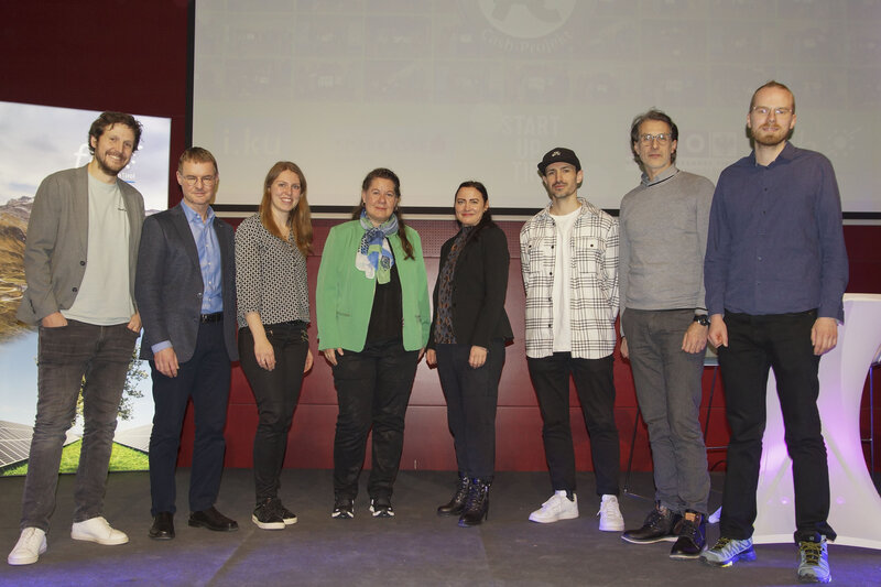 Das Jurorenteam der 7-Euro-Cash-Veranstaltung, das auf einer Bühne im Veranstaltungsraum der FH Kufstein Tirol steht. | © FH Kufstein Tirol