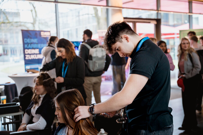 Ein Friseur stylt eine Besucherin der Meet & Match.  | © FH Kufstein Tirol