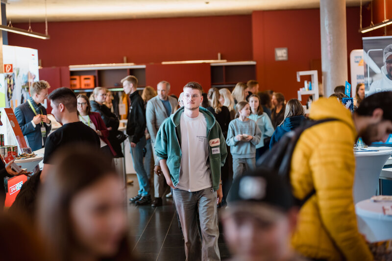 Menschen gehen durch einen großen Raum voller Besucher:innen auf der Karrieremesse Meet & Match. | © FH Kufstein Tirol