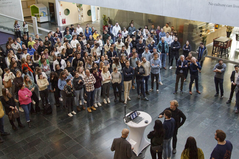 Eine große Gruppe von Menschen versammelt sich in der modernen Aula der FH Kufstein Tirol. | © FH Kufstein Tirol