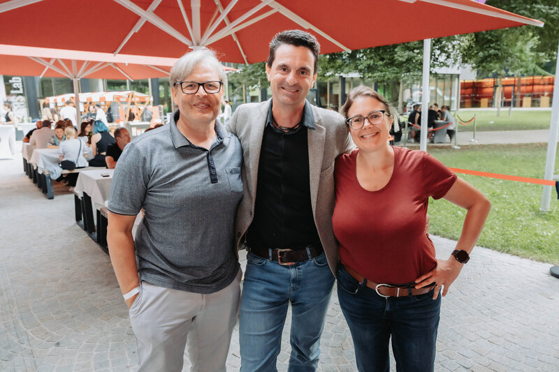 event-homecoming-dreiergruppe-eingangsbereich-2025 | © FH Kufstein Tirol Drei Teilnehmer:innen stellen sich für ein Portrait auf. | © FH Kufstein Tirol