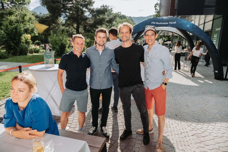 event-homecoming-gruppe-eingangsbereich-2025 | © FH Kufstein Tirol Mehrere lächelnde Besucher:innen wenden sich der Kamera für einen Moment zu. | © FH Kufstein Tirol