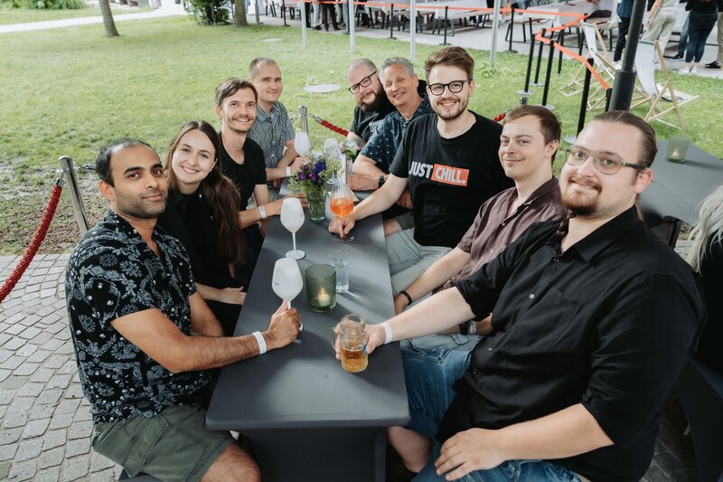 event-homecoming-it-aussenbereich-2025 | © FH Kufstein Tirol Gäst:innen lachen ungezwungen, während sie für einen Schnappschuss posieren. | © FH Kufstein Tirol