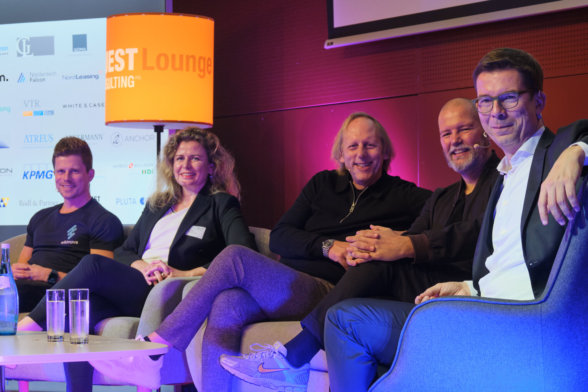 2024_Panel | © FH Kufstein Tirol Gruppenbild auf einer Bühne, vier Männer und eine Frau sitzen entspannt auf einem Sofa und lächeln in die Kamera | © FH Kufstein Tirol
