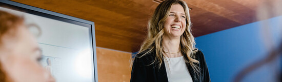 Dozentin hält eine Präsentation vor Teilnehmenden in einem Seminarraum