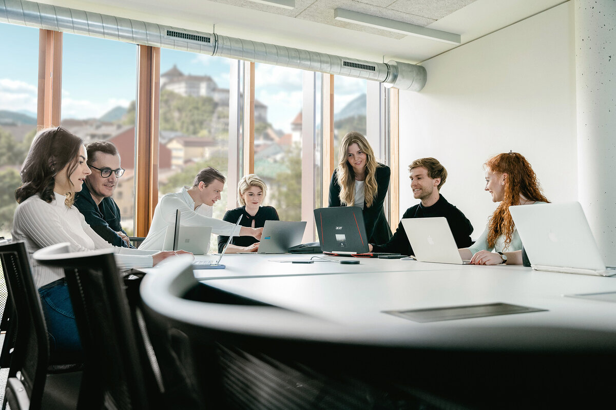 Meetingroom_Besprechung_3 | © FH Kufstein Tirol Sieben Personen arbeiten versammelt um einen Tisch an ihren Laptops und besprechen Dinge miteinander. | © FH Kufstein Tirol