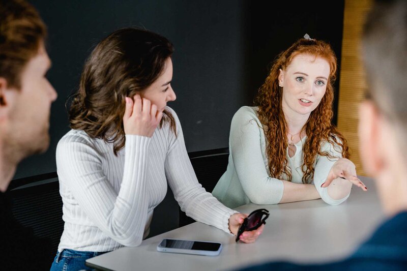 Studierende der FH Kufstein Tirol diskutieren angeregt in einer Projektarbeit und tauschen Ideen aus.
