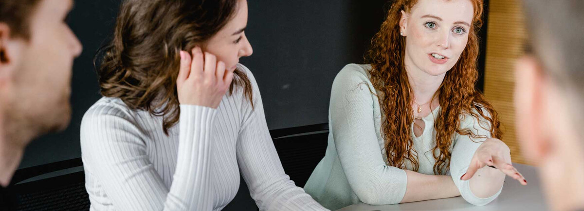 Studierende der FH Kufstein Tirol diskutieren angeregt in einer Projektarbeit und tauschen Ideen aus.