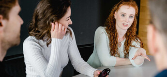 Studierende der FH Kufstein Tirol diskutieren angeregt in einer Projektarbeit und tauschen Ideen aus.