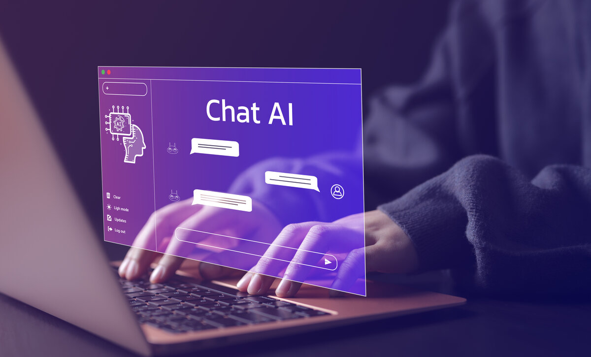 Hände, die auf einem Laptop tippen, mit einer digitalen Benutzeroberfläche für einen KI-Chatbot, dargestellt in einem violetten Overlay. | © AdobeStock.Supatman