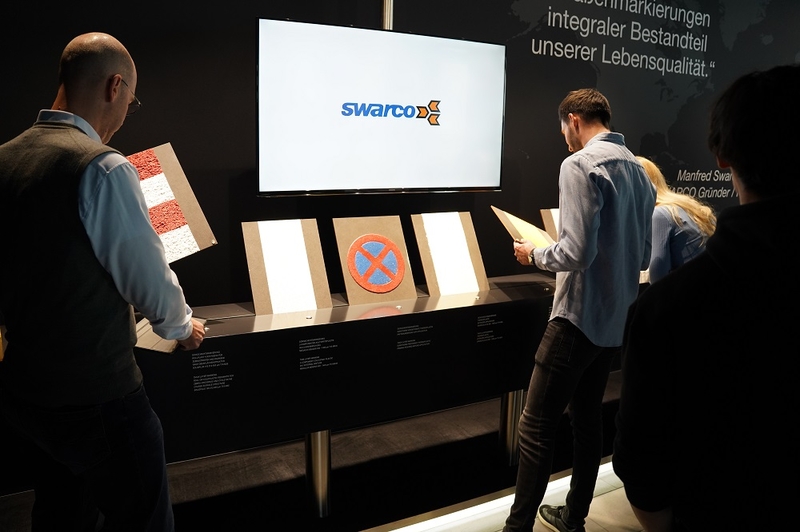 Student steht for einem Ausstellungstisch mit Bildschirmscreen Swarco | © FH Kufstein Tirol