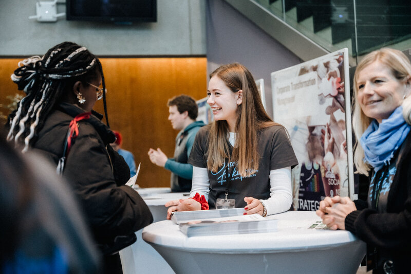 Gäste-und-Studierende-am-Tag-der-offenen-Tür-FH-Kufstein-Tirol | © FH Kufstein Tirol Gut gelaunte Studierende und Gäste an Infostand der FH Kufstein Tirol am Tag der offenen Tür | © FH Kufstein Tirol