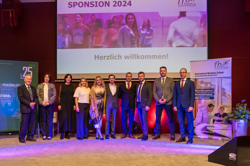 Spondierende und Lehrende auf dem Podium des Festsaals der FH Kufstein Tirol anlässlich der Master-Sponsion.  | © FH Kufstein Tirol