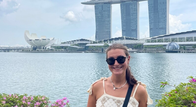 bernrieder-malaysia-skyline | © Magdalena Bernrieder posiert vor einer modernen Skyline in Malaysia, mit einem ruhigen Gewässer im Hintergrund. Privat | © Magdalena Bernrieder posiert vor einer modernen Skyline in Malaysia, mit einem ruhigen Gewässer im Hintergrund.