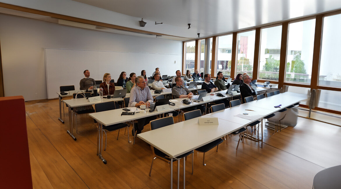 Teilnehmende-des KI-Workshops-bei-der Diskussion | © FH Kufstein Tirol Workshop-Teilnehmer:innen sitzen an Tischen und folgen der Präsentation. Einige machen sich Notizen oder arbeiten an Laptops. | © FH Kufstein Tirol