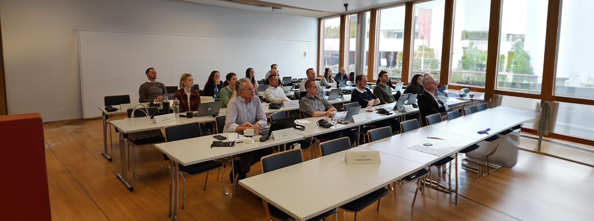 Teilnehmende-des KI-Workshops-bei-der Diskussion | © FH Kufstein Tirol Workshop-Teilnehmer:innen sitzen an Tischen und folgen der Präsentation. Einige machen sich Notizen oder arbeiten an Laptops. | © FH Kufstein Tirol