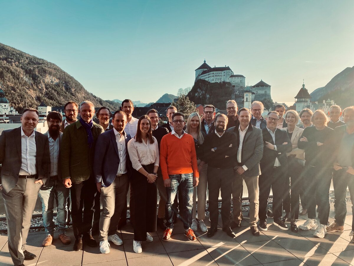 Workshop CTuP 2025 | © FH Kufstein Tirol Menschen stehen auf einer Dachterrasse und schauen in die Kamera. Im Hintergrund eine Festung. | © FH Kufstein Tirol