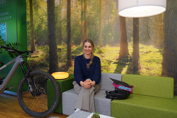 Masterstudentin Simone Kellner sitzt in der Bibliothek der FH Kufstein Tirol auf einer grün-grauen Couch und spricht über ihre Mountainbike-Leidenschaft und ihr Engagement für Inklusion. | © FH Kufstein Tirol