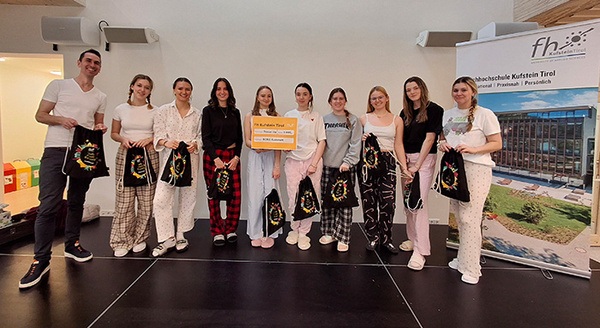 Lehrer und Schülerinnen mit Scheck und Stofftaschen | © FH Kufstein Tirol