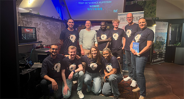 Eine Gruppe von Menschen steht gemeinsam in einem Raum. Einige haben die gleichen T-Shirts an. | © FH Kufstein Tirol
