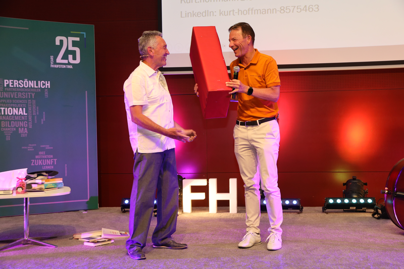 Prof. (FH) Mag. Kurt Hoffmann erhält vom Geschäftsführer der FH Kufstein Tirol, Prof. (FH) Dr. Thomas Madritsch, ein Präsent.  | © FH Kufstein Tirol