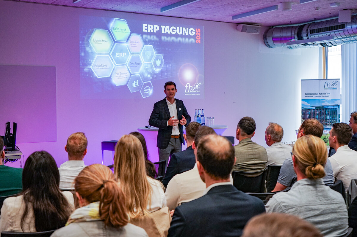 ERP-Fachtagung Begrüßung | © FH Kufstein Tirol Eine Gruppe von Menschen in formeller Kleidung sitzt in einem modernen Konferenzraum während einer Präsentation. Im Hintergrund sind Präsentationsfolien zu sehen. | © FH Kufstein Tirol