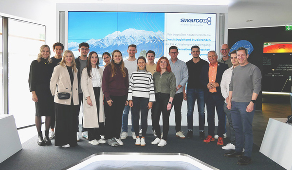 Personengruppe steht beisammen vor einer digitalen Leinwand. | © SWARCO AG ki-adaptiert